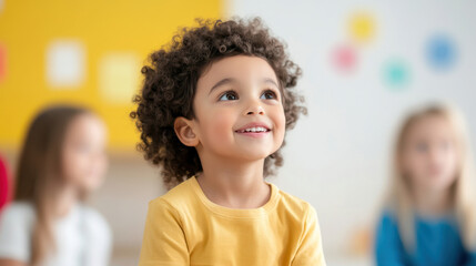 Happy child with curly hair in classroom setting, engaging with peers. bright background adds cheerful atmosphere, enhancing joyful expression of boy