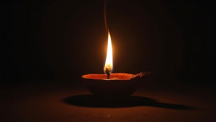 A traditional Indian clay diya (oil lamp) sitting on a dark surface, its flame glowing brightly but casting no light or shadow around it. A surreal take on deception, false hope