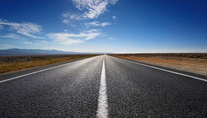 Naklejka premium long open road stretching into distant horizon under vast blue sky