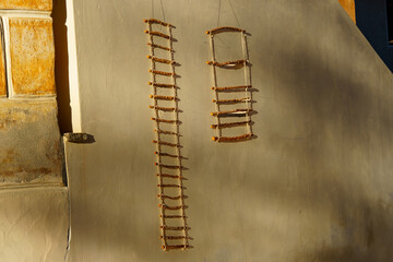 Two rope ladders (decorative trellis, climbing aid) on a light-coloured house wall