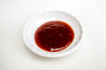 Plate of chili sauce on a white background