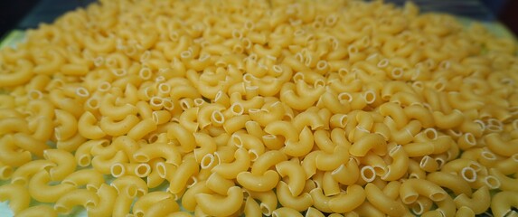 Large-sized raw pasta cones.
Macaroni cones scattered on the surface. Classic pasta for Italian...