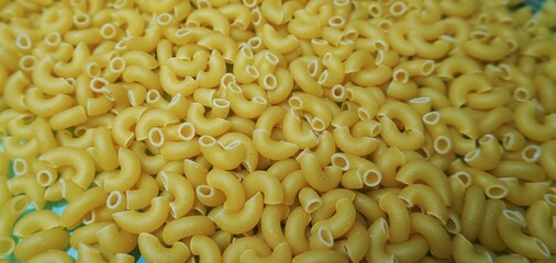 Raw pasta horns.
Large-scale pasta horns. Classic pasta shape, crumbled pasta. Perfect for culinary themes and Italian cuisine.