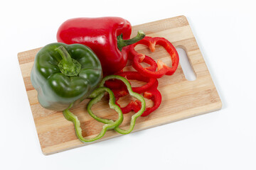 Rodajas de Pimientos Rojos y Verdes sobre Tabla de Madera