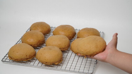 Coffee milk buns are served using a cooling rack that is placed on a white background (isolated white).