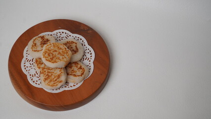 Wingko babat is served using a brown container made of wood and placed on a white background (isolated white).