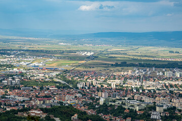 Aerial view of Brasov surrounded by the Carpathian mountains dotted with ski resorts including the ever popular Boiana Brasov. Romania, the Balkans, Eastern Europe