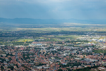 Aerial view of Brasov surrounded by the Carpathian mountains dotted with ski resorts including the ever popular Boiana Brasov. Romania, the Balkans, Eastern Europe