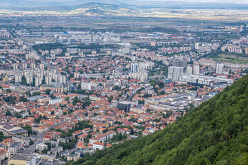Obraz premium Aerial view of Brasov surrounded by the Carpathian mountains dotted with ski resorts including the ever popular Boiana Brasov. Romania, the Balkans, Eastern Europe