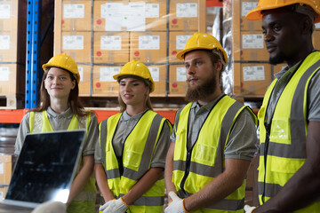 Distribution warehouse, Man and woman workers, Discussing work together, Warehouse worker wear...
