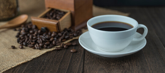 Background image with coffee beans scattered on the table and a cup of coffee