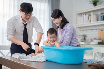 Parents enjoying a joyful bath time moment with their baby at home in a bright and cozy living room...