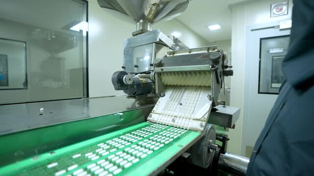 Pharmaceutical medicine tablet packing machine. packaging tablets in blister, alu alu packing. equipment sealing tablets in packets. automatic sealing machine in a pharmaceutical manufacturing.