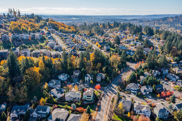 Aerial drone view of Happy Valley, Oregon, in autumn, showcasing vibrant fall foliage, residential neighborhoods, tree-lined streets, rolling hills, and suburban landscapes with golden and red leaves