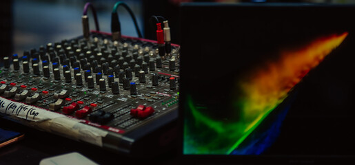 Mixer control and laptop screen. Backstage controls on an audio mixer, sound mixer, laptop....