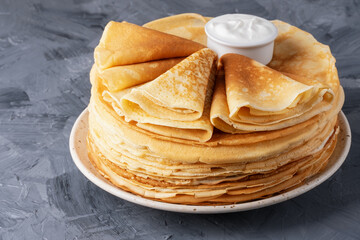 Stack of traditional russian pancakes blini on gray background. Homemade russian thin pancakes...