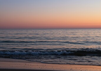 Obraz premium Peaceful seaside sunset with gentle waves and colorful sky tranquility