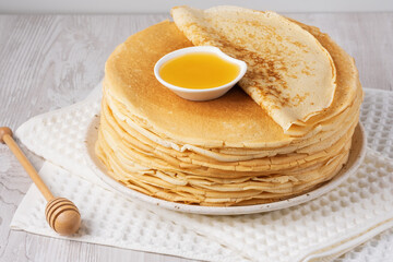 Stack of traditional russian pancakes blini on a white table. Homemade russian thin pancakes blini....