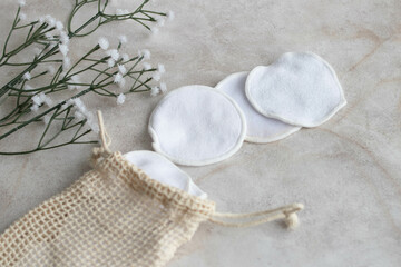reusable cotton pads with storage bag on plain background in
