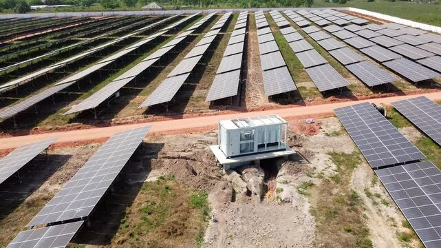 Solar PV farm industrial inverter module with visible DC combiner box cables during installation -aerial low close up view