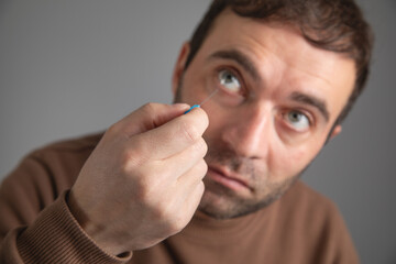 Man showing syringe needle on eye.