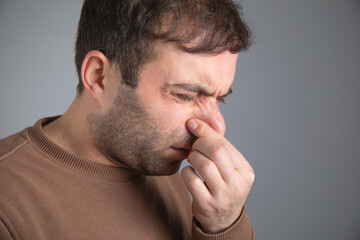 Caucasian man disgusted expression for stink.