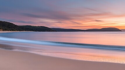 Fototapeta premium Serene beach landscape reflecting a vibrant sunset in pastel hues