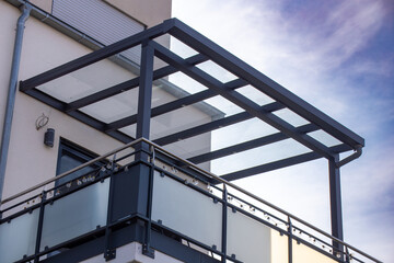 Schöne Balkonüberdachung aus Glas und Aluminium an einem Wohnhaus
