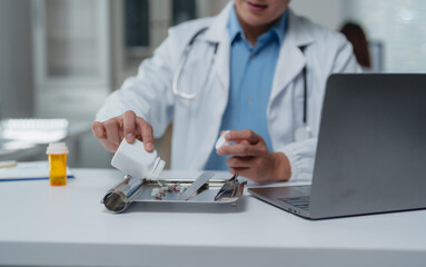 Pharmacist pouring pills from a prescription bottle onto a counting tray, preparing medication for a patient in a modern pharmacy setting with laptop and pill bottles