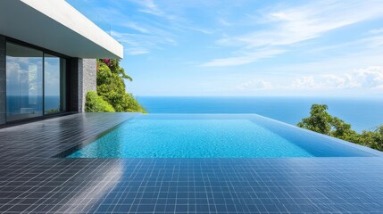 Obraz premium Sleek black-tiled infinity pool blending into a panoramic ocean view
