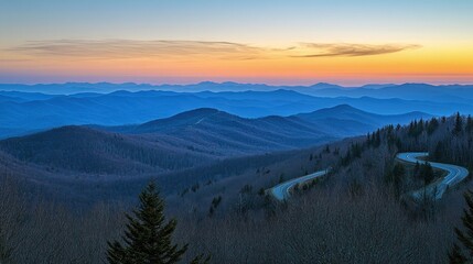 Obraz premium Mountain range with winding road under a colorful twilight sky