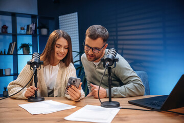 Tow people, together. Radio hosts recording podcast
