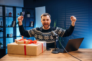 Christmas present, gift box. Man with microphone in the studio, conception of podcast
