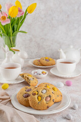 Easter cookies. Tradition american cookies with chocolate mini eggs candy on a white plate. Easter dessert. Copy space.