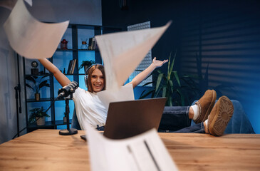Celebrating, with hands up. Woman is hosting radio podcast with microphone and laptop