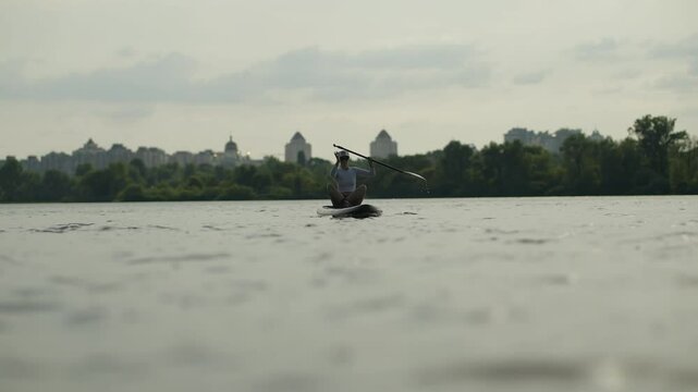 Athlete Paddling On Stand Up Paddleboard On River Surface. Active Lifestyle And Hobby 
