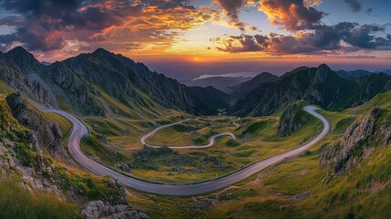 Winding road snakes through mountains at sunrise or sunset