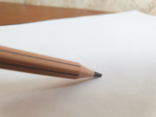 Simple wooden pencil, pencil line on sheet close-up.