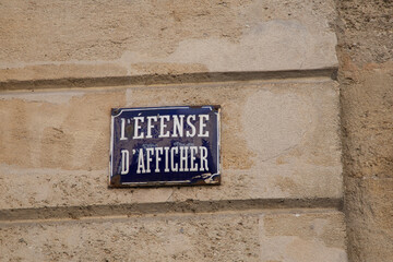 Fototapeta premium Prohibition to display on a wall defense d'afficher old vintage french text sign on building wall means Do not stick posters