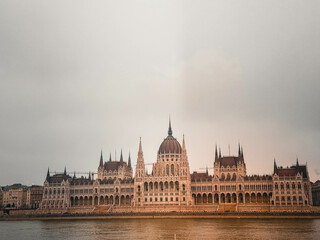 Fototapeta premium Hungarian Parliament Building on an Overcast Day A stunning view of the Hungarian Parliament Building in Budapest, Hungary, captured on a cloudy and moody day. The grand neo-Gothic architecture stands
