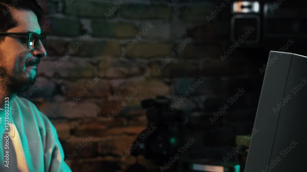 Poster man with glasses working on desktop pc computer from 1990's in dark basement room