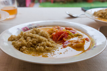 Quinoa porridge with shrimps and tomatoes on dish on table