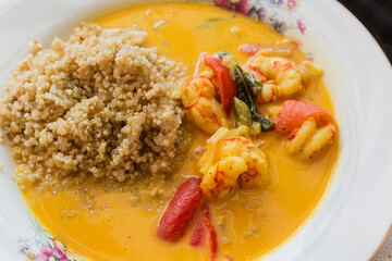 Quinoa porridge with shrimps and tomatoes on dish close-up