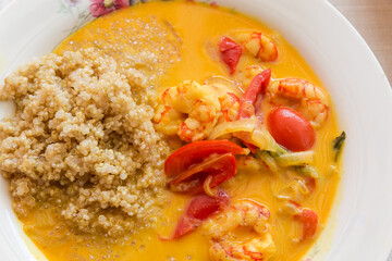 Quinoa porridge with shrimps and tomatoes on dish close-up