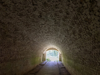 Fototapeta premium Tunnel lined with red bricks in the old fortress