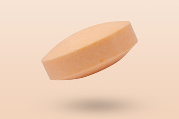 Orange medicine pill tablet flying on orange background