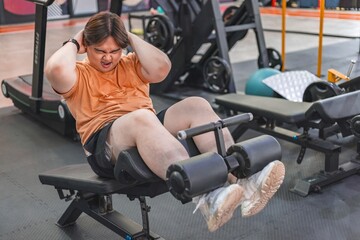 Close-up of fat man exercising struggles of an overweight individual at the gym