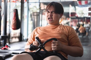 Fototapeta premium Overweight man struggles to exercise gym setting personal challenge tired and exhausted