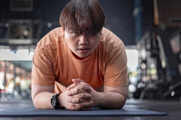 Exhausted overweight man struggles with exercise in gym tired but determined to improve