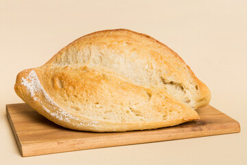Freshly baked bread on cutting board against white wooden background. perspective view bread with copy space